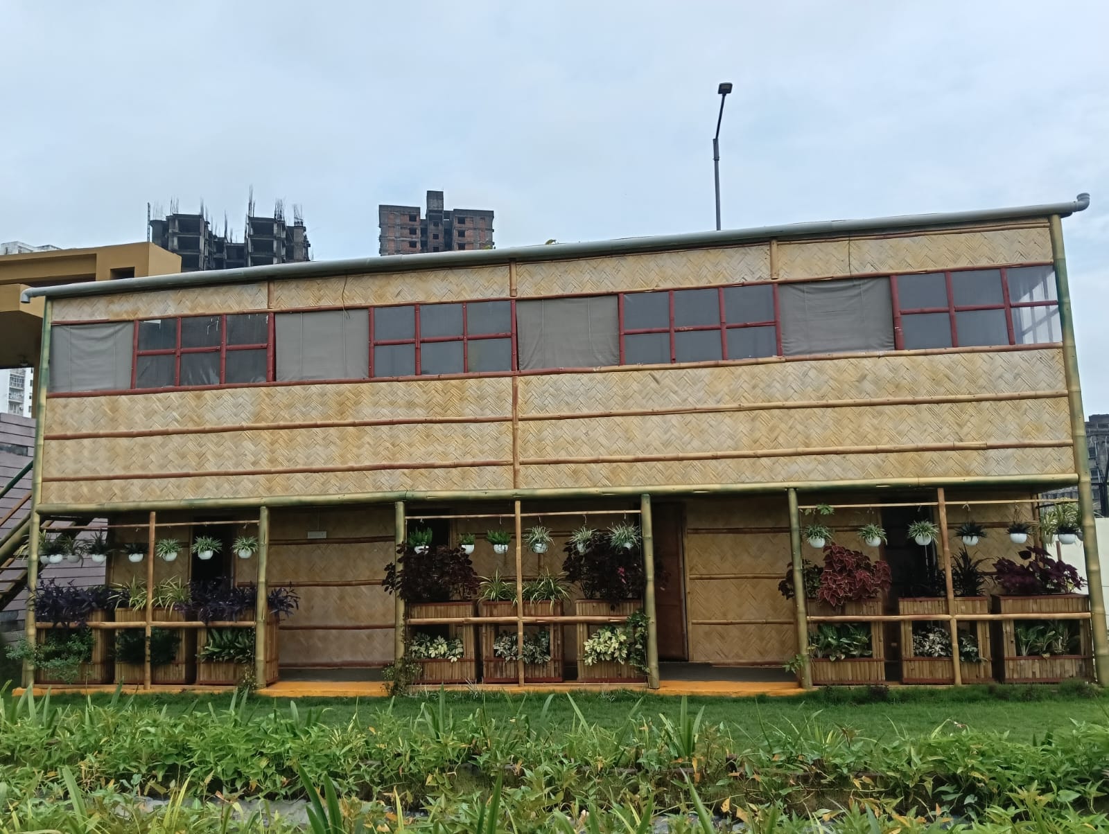 The completed habitat — scaffolding gone, planters installed, landscaped garden with green lawn