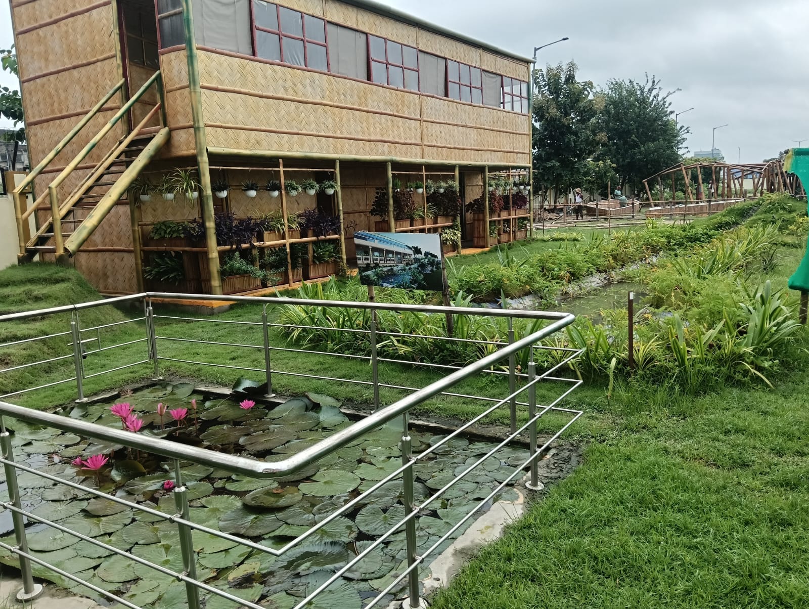 The Biophilic Habitat at IIT Kharagpur Research Park — a two-story bamboo structure with lotus pond and landscaped garden in the foreground