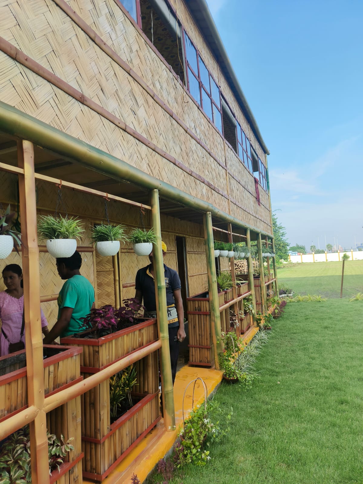 Side view with people working inside, hanging planters along the full facade